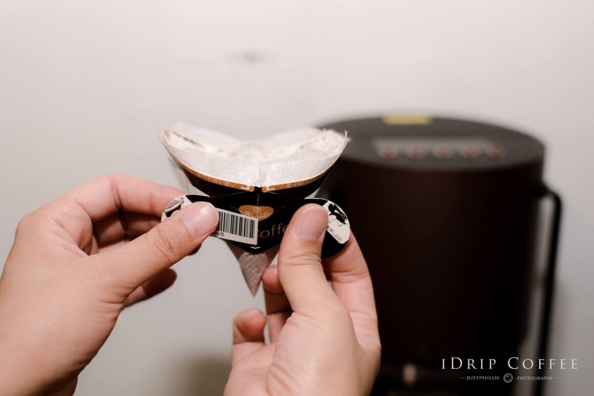 用手撐起咖啡包兩側的小耳朵，讓兩側小耳朵與咖啡包的條碼呈現一直線狀態。